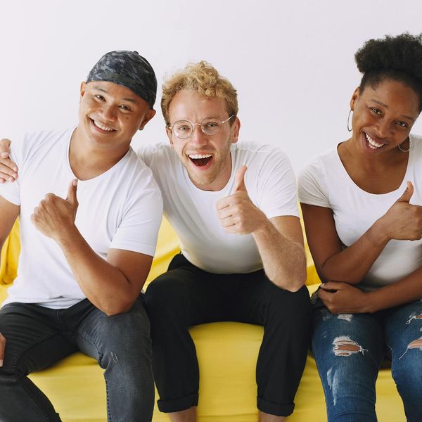 Diverse group of people smiling in a bright yoga studio.